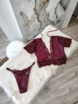 Conjunto de lencería color bordó, compuesto por un top de lycra, microtul y encaje elastizado con broche de gancho y espalda de microtul con detalles de encaje, y una tanga regulable de los mismos materiales con forro de algodón.