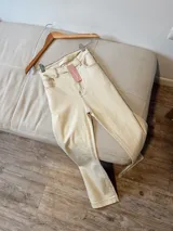 Jean con lycra en color beige, de corte ajustado y diseño clásico.
