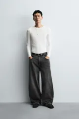 Pantalón de jeans de algodón, corte baggy fit, tiro medio, con efecto lavado en tonos grises y verdes. Presenta cinco bolsillos y cierre frontal con cremallera y botón.