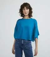 Blusa celeste de viscosa con textura satinada, cuello redondo, manga corta con sisa desplazada y abertura en la espalda.