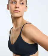 Top deportivo negro de poliamida y elastano, con breteles finos, copas removibles, escote en la espalda y sin estampado.