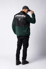 Campera negra con la parte superior de tela tipo rompevientos con dos bolsillos con solapa y la parte inferior de micro polar. Tiene cierre frontal y cuello alto.