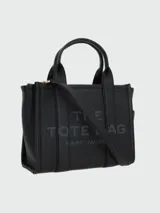 Bolso tote pequeño de cuero color negro, con doble asa corta y correa lateral. Estampado frontal con el nombre de la marca y el tipo de bolso.