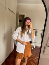 Pollera de cuero con detalles en tachas y diseño corto.