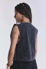 Chaleco negro de jean con bordados y apliques plateados.