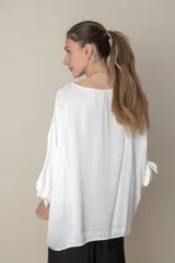 Blusa italiana holgada de color negro con cuello redondo y mangas 3/4 con detalle de lazos.