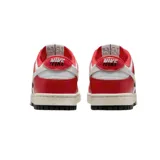 Championes Nike Dunk Low, color blanco con detalles en rojo y negro.