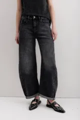 Pantalón de jean negro con corte amplio y ruedo doblado.