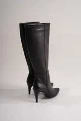 Botas de cuero ecológico plateadas, con taco fino de 9,5 cm y cierre lateral interno para mayor comodidad.