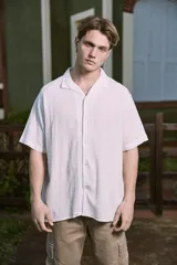 Camisa blanca de popelina con cuello resort, mangas cortas y cierre frontal con botones.