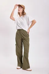 Pantalón cargo color verde oliva, de corte ancho y tiro alto, con bolsillos laterales y cierre frontal con cremallera y botón.