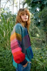 Chaqueta de tejido grueso multicolor con diseño de bloques y flecos en el ruedo.