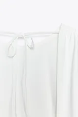 Top negro de cuello redondo y tirantes anchos. Detalle de escote en espalda con tira cruzada ajustable con lazada.