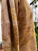 Remera de manga larga color beige con estampado botánico verde y amarillo, escote en V, corte ajustado y tajos laterales.