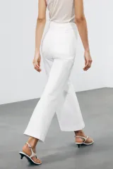 Pantalón de jean celeste de tiro alto y corte wide leg, con bolsillos frontales y traseros, cierre frontal con cremallera y botón metálico.
