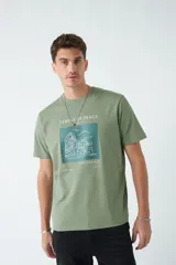 Remera verde militar de algodón con estampa en el frente con la frase "Temple of Peace" y un dibujo de un edificio.