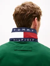 Campera náutica amplia reversible de nailon, con diseño color block en rojo, blanco y azul marino. Tiene capucha fija, cierre de cremallera oculto con botones a presión, puños y bajo elásticos, dos bolsillos ribeteados en la cintura, parche con logo de Tommy Hilfiger en el pecho y logo de Tommy Hilfiger en el cuello, las mangas y la espalda.