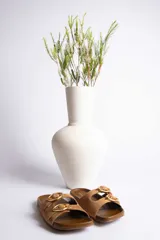 Sandalias de cuero color beige con dos tiras anchas y hebillas doradas ajustables.