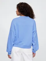 Buzo deportivo celeste con logo de la marca Gap en color blanco con diseño floral.
