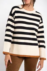 Sweater de rayas en blanco y negro con detalles en color marrón, de calce oversize y diseño fluido.