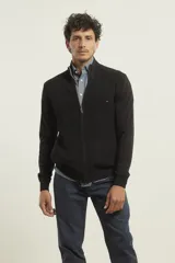 Cárdigan negro de punto con cierre frontal de metal, cuello alto, manga larga y bolsillos laterales.
