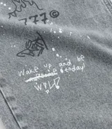 Pantalón masculino super baggy confeccionado en jeans sostenible con cintura con trabilla, cierre tradicional, bolsillos y estampa de grafiti.