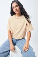 Remera negra de corte holgado con mangas ranglan y cuello redondo con bordado de estrellas blancas.