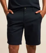 Bermuda masculina de corte slim, confeccionada en sarga lisa color blanco. Cuenta con bolsillos laterales, cierre con botón y cremallera, y trabillas para cinturón.
