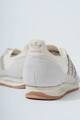 Championes Adidas SL 72 OG, color blanco hueso con detalles en gris topo, confeccionados en nylon y gamuza, con las tres tiras laterales en cuero sintético y suela de goma marrón.