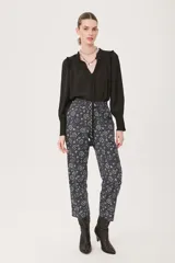 Pantalón babucha negro con estampado floral en tonos celeste y blanco.