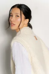 Chaleco de punto color crudo, con diseño oversized y sin mangas.