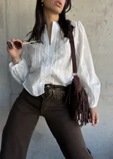 Camisa blanca con bordado floral, cuello mao y mangas largas abullonadas.