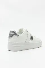Zapatillas blancas de símil cuero con recortes en gamuza y detalles metalizados plateados. Plataforma de 4,5cm de alto.