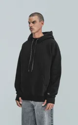 Hoodie negro oversize de frisa premium con capucha ajustable, cordones con texto y puños elastizados.