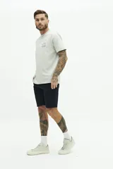 Bermuda de gabardina azul marino con logo bordado, bolsillos laterales y traseros, cierre con cremallera y botón, y presillas para cinturón.