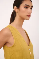 Vestido midi color borgoña, sin mangas, con escote en V, cierre frontal con botones y bolsillos laterales.