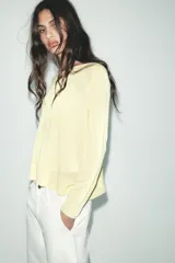 Jersey de punto color borgoña, con cuello redondo, manga larga y bajo con aberturas laterales.