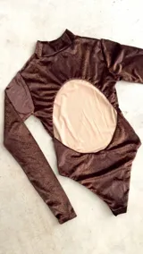 Body de terciopelo marrón con estampado de piel de serpiente, cuello alto, mangas largas con orificio para el pulgar y espalda descubierta.