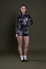 Conjunto de remera de manga larga con cuello alto y short ajustado, ambos con estampado batik en blanco y negro.