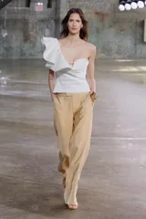 Pantalón de vestir color arena, de tiro medio y corte recto, confeccionado en hilatura con viscosa. Cuenta con bolsillos laterales, raya planchada en delantero y cierre frontal con cremallera, botón y gancho metálico.
