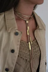 Aros tipo argolla grandes, de metal dorado. Diseño minimalista y elegante.