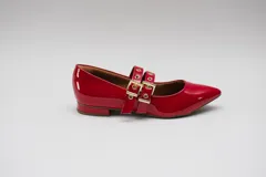 Chatitas rojas de charol con punta fina y dos tiras sobre el empeine con ojales metálicos y hebillas doradas.
