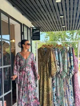 Vestido largo de polysilk con estampado paisley en tonos azul, celeste y dorado. Tiene escote en V, mangas largas acampanadas y corte amplio.