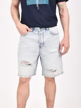 Bermuda de jean negro con roturas y corte a la rodilla.