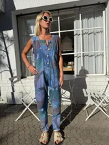 Mono largo de jean con estampado de hojas en tonos azules, marrones y verdes. Tiene botones frontales, corte vintage y bolsillos laterales.