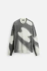 Jersey de punto gris con efecto tie-dye blanco, de corte relaxed fit, cuello redondo y mangas largas.