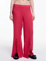 Pantalón ancho color blanco, de lino y viscosa, con tajos y lazos en la botamanga.