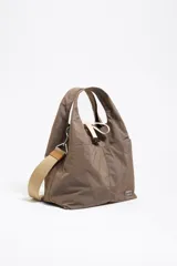 Bolso de mano Bimba y Lola de nailon color marrón topo, con estructura blanda, doble asa de mano y asa de tejido regulable. Cuenta con logo metálico, bolsillo interior, cierre de cordón e interior con etiqueta de tejido.