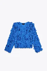 Chaqueta azul con cuello redondo y manga larga, con apliques de pétalos en toda la prenda y cierre frontal con botón a presión oculto.