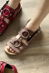 Sandalias planas de cuero color marrón chocolate, estilo gladiador con tiras anchas y aros metálicos plateados. Cuentan con plantilla anatómica y suela antideslizante.